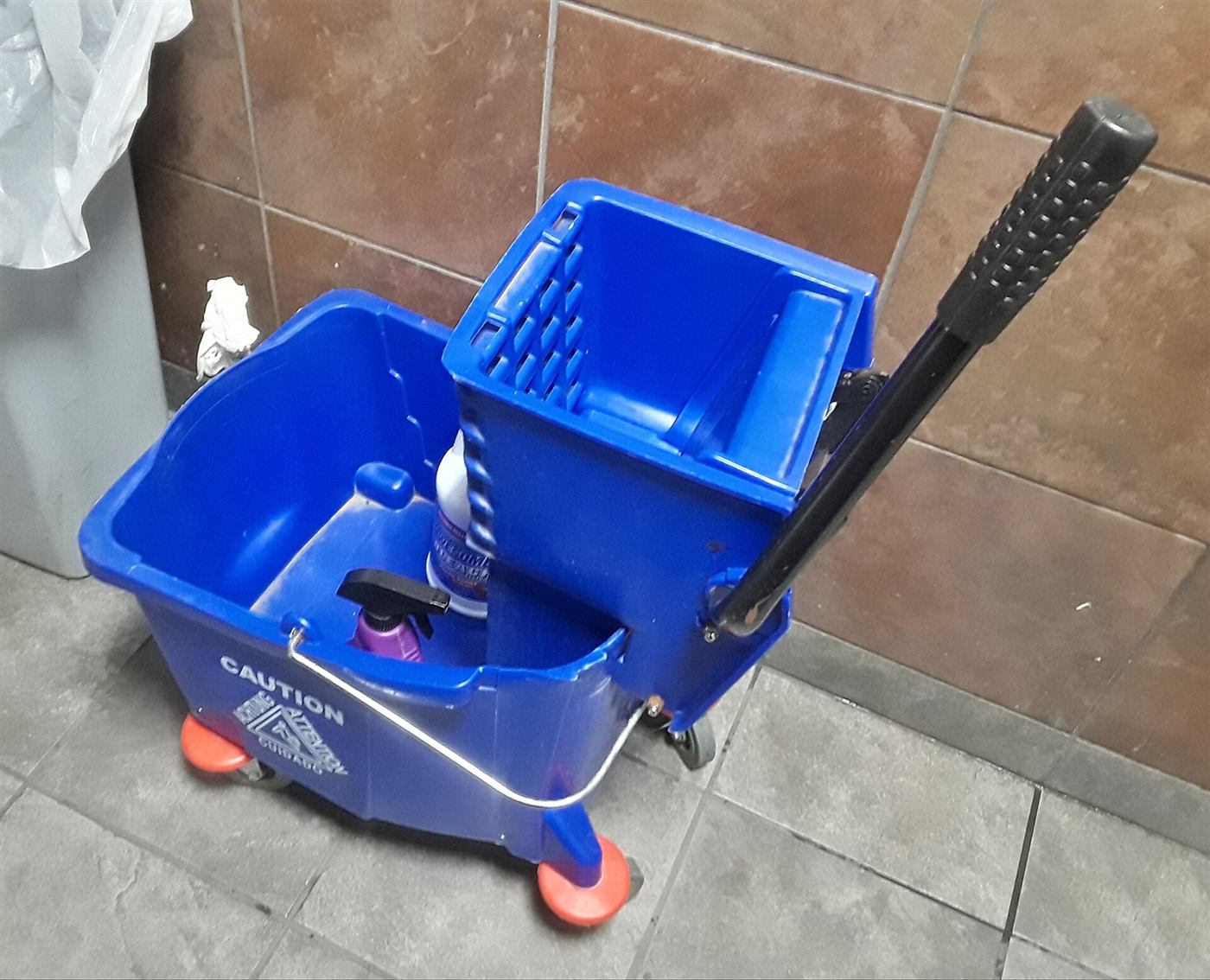 A blue mop bucket with a wringer